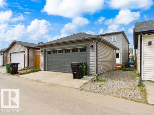 Detached garage with a dark gray sectional door and light gray horizontal siding - 17487 77 Street, Edmonton, AB - Outdoor