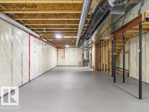 Unfinished basement featuring exposed wood joists, insulated walls, concrete flooring, and visible ductwork and structural beams - 17487 77 Street, Edmonton, AB - Indoor Photo Showing Basement