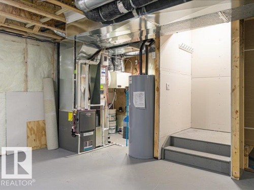 Unfinished basement area featuring exposed ceiling joists, insulation, utility systems, and a water heater - 17487 77 Street, Edmonton, AB - Indoor Photo Showing Basement