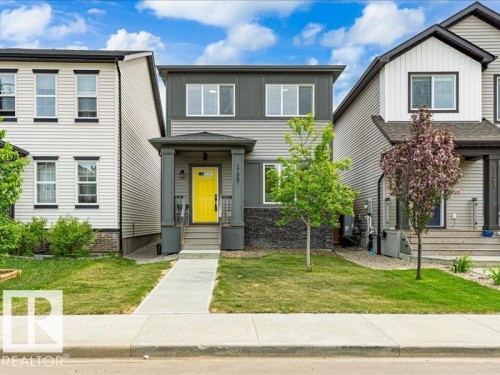 Modern facade with dark gray siding, light gray siding, and a stone accent foundation - 17487 77 Street, Edmonton, AB - Outdoor With Facade