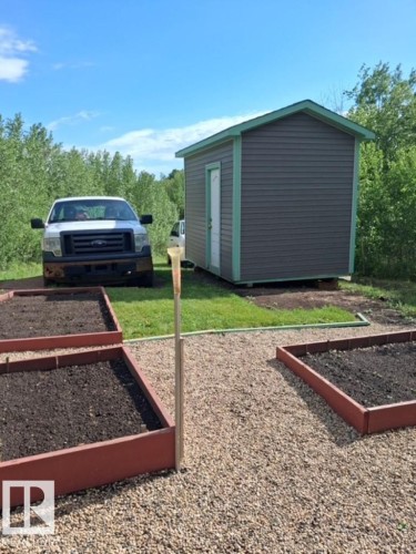 Outdoor storage shed featuring horizontal siding and a white entry door - 204 Sandy Beach Way, Rural Two Hills County, AB - Outdoor With Exterior