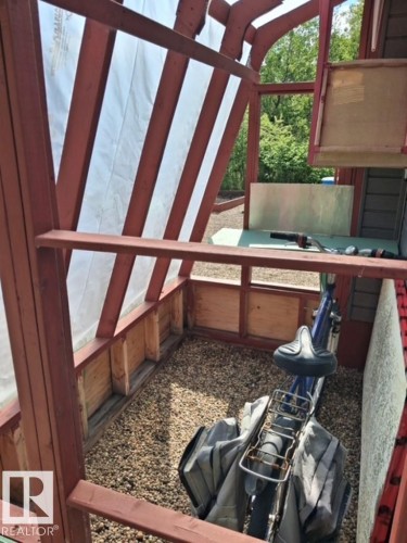 Wood-framed outdoor structure featuring a gravel floor, slatted wood sides, and a translucent roof - 204 Sandy Beach Way, Rural Two Hills County, AB - Indoor Photo Showing Other Room