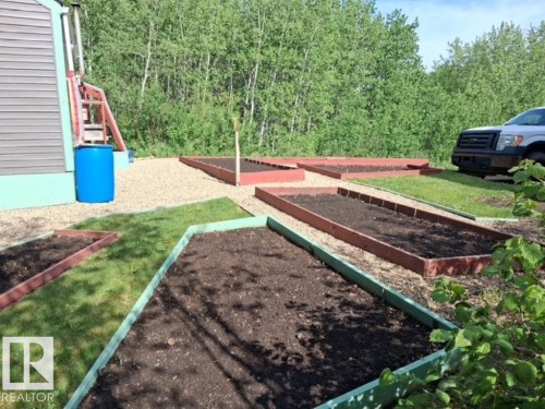 Outdoor space featuring multiple raised garden beds with rich soil - 204 Sandy Beach Way, Rural Two Hills County, AB - Outdoor