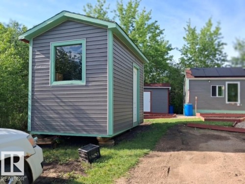 Compact structure with grey horizontal siding and light green trim - 204 Sandy Beach Way, Rural Two Hills County, AB - Outdoor With Exterior