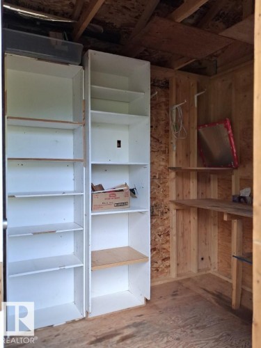 Built-in white shelving and unfinished wood paneling - 204 Sandy Beach Way, Rural Two Hills County, AB - Indoor