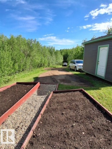 Raised garden beds with dark soil and gravel pathways - 204 Sandy Beach Way, Rural Two Hills County, AB - Outdoor