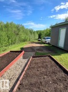 Raised garden beds with dark soil and gravel pathways - 