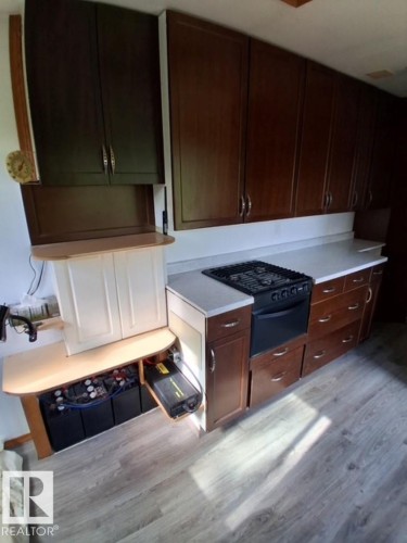 Compact kitchen area featuring wood-finish flooring and white countertops - 204 Sandy Beach Way, Rural Two Hills County, AB - Indoor Photo Showing Other Room
