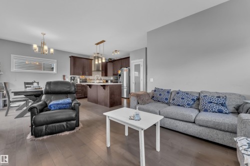 Open-concept living area featuring rich wood-finish flooring - 1942 Chapman Road Sw, Edmonton, AB - Indoor Photo Showing Living Room