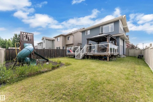 Spacious backyard featuring a wooden deck with a built-in gazebo, glass panel railings, and steps to the lawn - 1942 Chapman Road Sw, Edmonton, AB - Outdoor With Deck Patio Veranda With Backyard