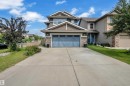 Two-story residence featuring a blue garage door and stone accents on the facade - 1942 Chapman Road Sw, Edmonton, AB  - Outdoor With Facade 