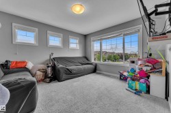 Carpeted room featuring multiple windows, a large fixed window overlooking residential structures, and three smaller rectangular windows - 
