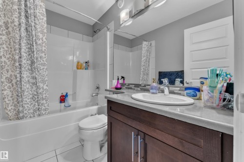 Bathroom featuring a white bathtub, toilet, and a vanity with a white oval sink - 1942 Chapman Road Sw, Edmonton, AB - Indoor Photo Showing Bathroom