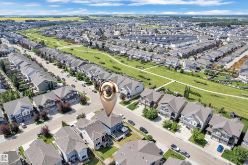 Residential street with single-family homes featuring a variety of architectural styles, paved roadways, and mature landscaping - 1942 Chapman Road Sw, Edmonton, AB - Outdoor With View