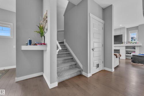 Interior staircase featuring carpeted treads and risers, complemented by wood-finish flooring - 1942 Chapman Road Sw, Edmonton, AB - Indoor Photo Showing Other Room