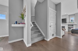 Interior staircase featuring carpeted treads and risers, complemented by wood-finish flooring - 