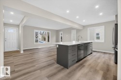 Open-concept interior featuring light gray walls, wood-finish flooring, and recessed lighting - 