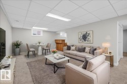 Spacious lower-level area featuring light gray wall paint, recessed lighting, and carpet flooring - 