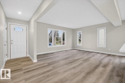 Expansive living space featuring wood-finish flooring and neutral wall tones - 
