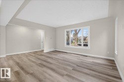 Spacious interior featuring wood-finish flooring, neutral wall tones, and recessed ceiling details - 