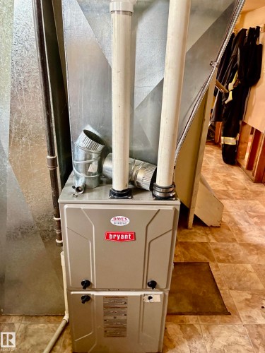 Forced air heating system by Bryant, featuring metal ductwork and PVC venting - 5206 51Ave, Willingdon, AB - Indoor Photo Showing Basement
