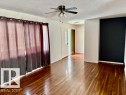 Spacious room featuring wood-finish flooring, a ceiling fan, and white walls with a contrasting accent wall - 5206 51Ave, Willingdon, AB  - Indoor Photo Showing Other Room 