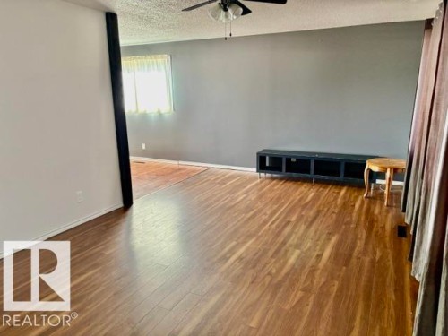 Spacious room featuring wood-finish flooring, a ceiling fan, and a neutral color palette - 5206 51Ave, Willingdon, AB - Indoor Photo Showing Other Room