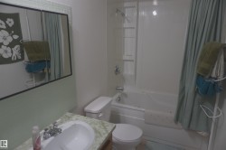 Bathroom featuring a built-in shower/tub combination, vanity with an integrated sink, wall-mounted mirror, and tile backsplash - 