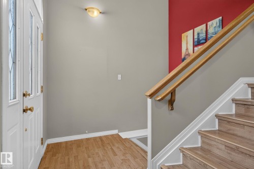Entryway featuring wood-finish flooring, a white paneled door with leaded glass inserts, and brass hardware - 3211 Mcphadden Place Sw, Edmonton, AB - Indoor Photo Showing Other Room