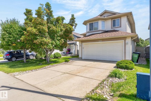 Two-story residence featuring light-colored siding and a brown shingle roof - 3211 Mcphadden Place Sw, Edmonton, AB - Outdoor