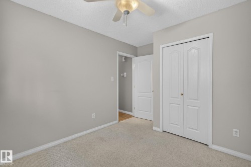 Bedroom featuring a ceiling fan, light gray wall paint, white trim, and light-colored carpet flooring - 3211 Mcphadden Place Sw, Edmonton, AB - Indoor