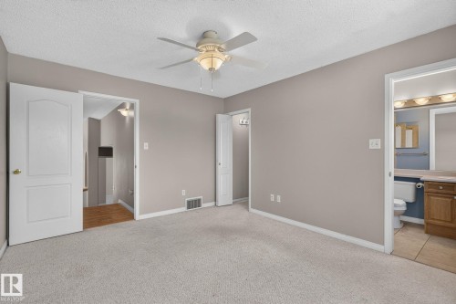 Carpeted room featuring a ceiling fan with integrated lighting, a panel door, and neutral wall tones - 3211 Mcphadden Place Sw, Edmonton, AB - Indoor Photo Showing Other Room