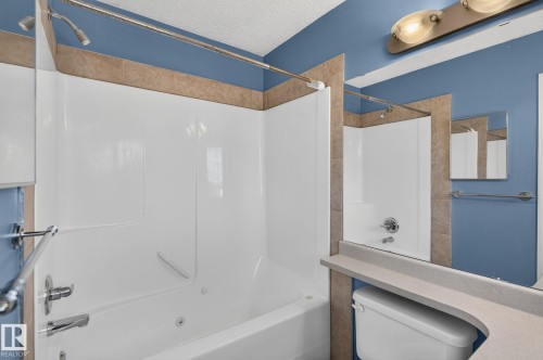 White composite tub and shower combination with chrome fixtures - 3211 Mcphadden Place Sw, Edmonton, AB - Indoor Photo Showing Bathroom