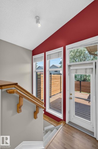 Stairwell with wood-finish flooring and a natural wood handrail - 3211 Mcphadden Place Sw, Edmonton, AB - Indoor Photo Showing Other Room