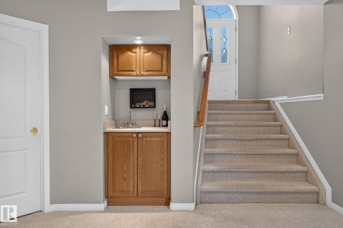 Built-in wet bar featuring wood cabinetry, stainless steel sink, and recessed lighting - 3211 Mcphadden Place Sw, Edmonton, AB - Indoor Photo Showing Other Room