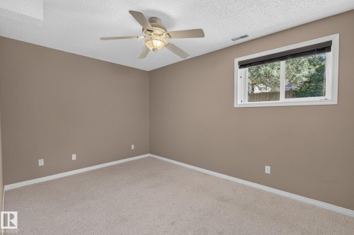 Carpeted room with a ceiling fan light fixture, a single window, and neutral wall paint - 3211 Mcphadden Place Sw, Edmonton, AB - Indoor Photo Showing Other Room