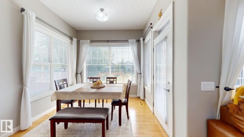 Dining area featuring wood-finish flooring and multiple windows - 335 62 Street Sw, Edmonton, AB - Indoor Photo Showing Dining Room