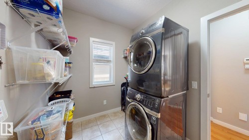 Laundry area featuring tile flooring, a window with horizontal blinds, and wall-mounted wire shelving - 335 62 Street Sw, Edmonton, AB - Indoor Photo Showing Laundry Room