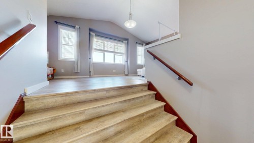 Wide staircase featuring wood-finish treads and risers, complemented by a cherry wood handrail - 335 62 Street Sw, Edmonton, AB - Indoor Photo Showing Other Room