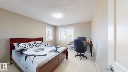 Bedroom featuring a rich wood-tone bed frame, soft neutral-toned walls, and carpet flooring - 335 62 Street Sw, Edmonton, AB - Indoor Photo Showing Bedroom