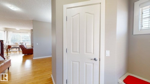 White paneled door with polished chrome hardware, wood-finish flooring, and neutral wall tones - 335 62 Street Sw, Edmonton, AB - Indoor Photo Showing Other Room