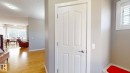 White paneled door with polished chrome hardware, wood-finish flooring, and neutral wall tones - 335 62 Street Sw, Edmonton, AB  - Indoor Photo Showing Other Room 