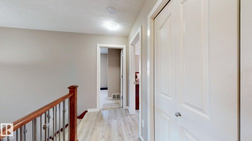 Upper hallway featuring wood-finish flooring, light grey painted walls, and white trim - 335 62 Street Sw, Edmonton, AB - Indoor Photo Showing Other Room