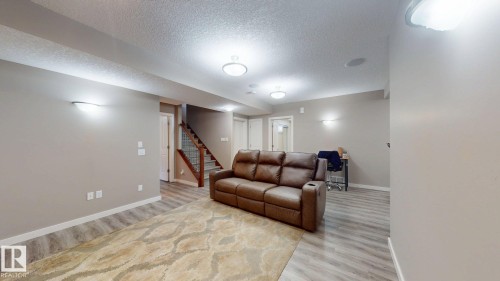 Spacious finished lower level featuring light wood-finish flooring, recessed ceiling lighting, and a built-in sound system - 335 62 Street Sw, Edmonton, AB - Indoor