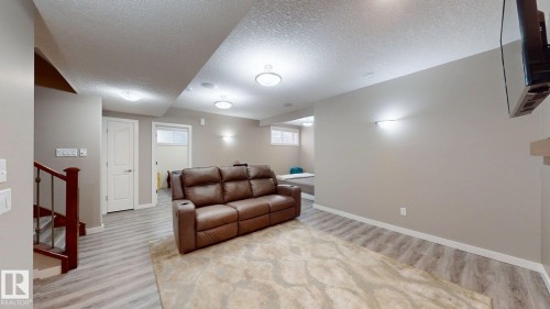 Spacious lower level featuring wood-finish flooring, recessed lighting, and a neutral color palette - 335 62 Street Sw, Edmonton, AB - Indoor Photo Showing Other Room