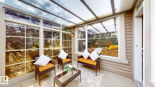 Enclosed sunroom featuring a transparent roof, multiple large windows with muntins, and textured siding - 335 62 Street Sw, Edmonton, AB - Indoor Photo Showing Other Room