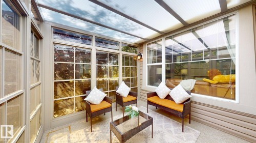 Enclosed patio featuring a clear panel roof, full-height windows, exterior sconce lighting, and a neutral-toned hard surface floor - 335 62 Street Sw, Edmonton, AB - Indoor Photo Showing Other Room