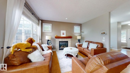 Living area featuring a gas fireplace with a tiled surround and wood mantel - 335 62 Street Sw, Edmonton, AB - Indoor Photo Showing Living Room With Fireplace