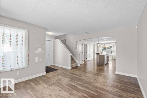 Spacious main living area featuring wood-finish flooring, light grey wall tones, and white trim - 1627 167 Street Sw, Edmonton, AB - Indoor