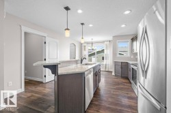 Modern kitchen featuring wood-finish flooring, recessed lighting, and stainless steel appliances - 